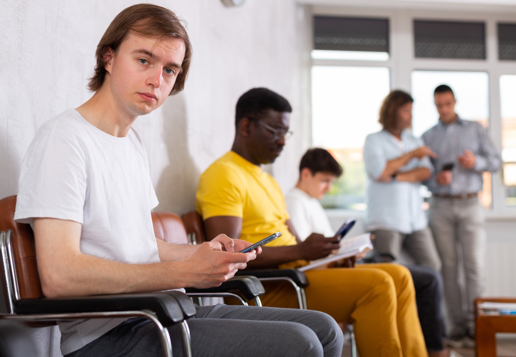 Young,male,patient,sitting,on,the,bench,in,waiting,room